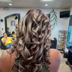 Close-up of beautifully styled wavy, curl and blonde hair against a salon background